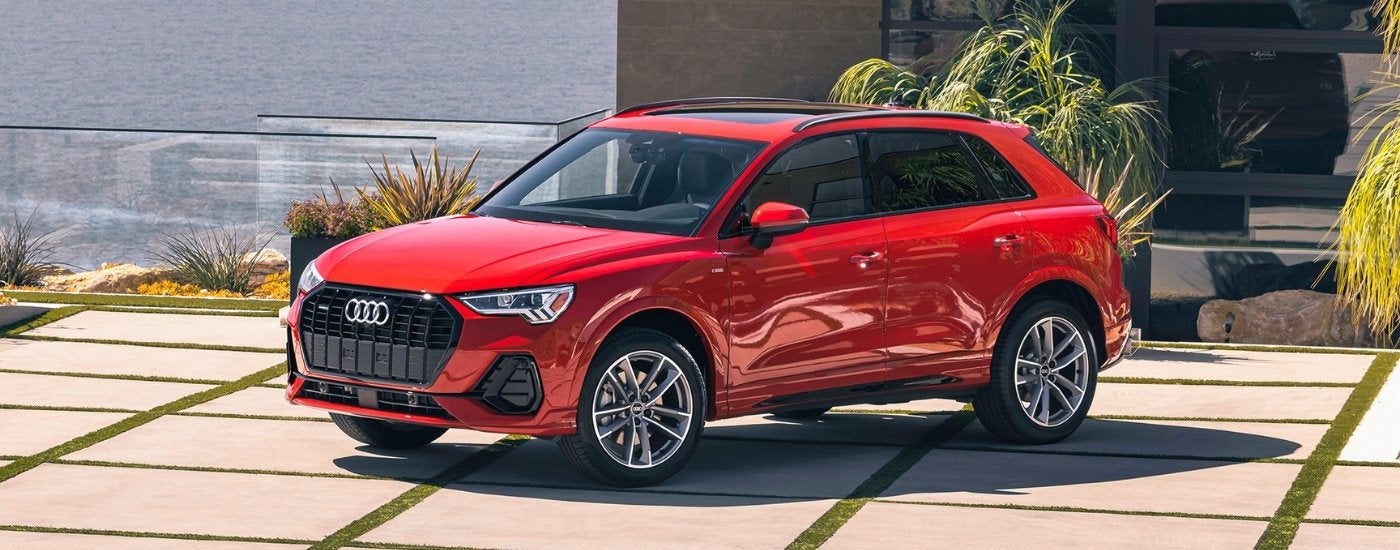 A red 2024 Audi Q3 on a driveway after leaving an Audi dealer.